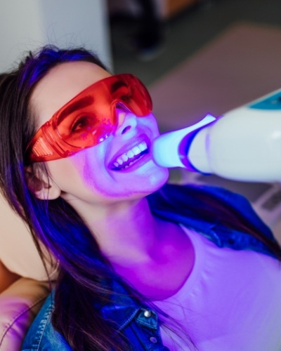 Woman in dental chair getting professional teeth whitening