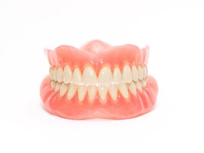 Full upper and lower dentures against white background