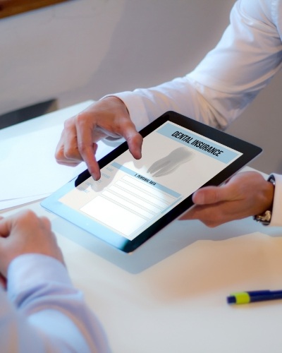 Two people looking at dental insurance forms on a tablet