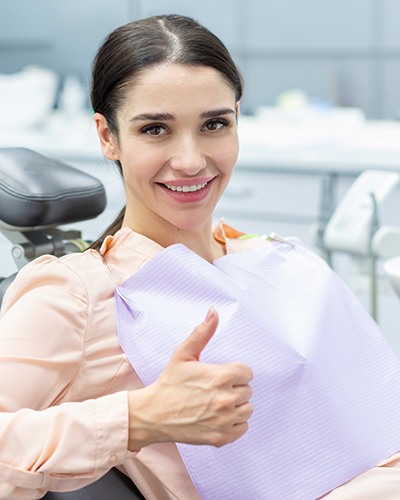 Happy dental patient making thumbs up gesture