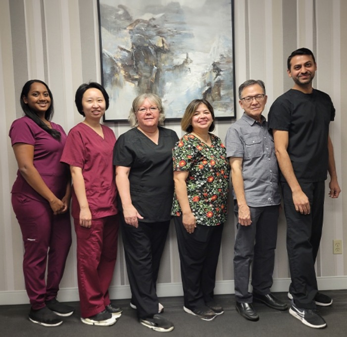 Smiling Meadowvale Family Dentistry team members standing against a wall