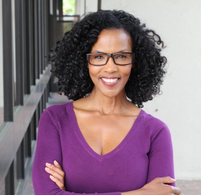 Woman in purple blouse smiling after restorative dentistry in Mississauga