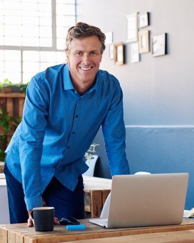 Man standing up at desk with laptop