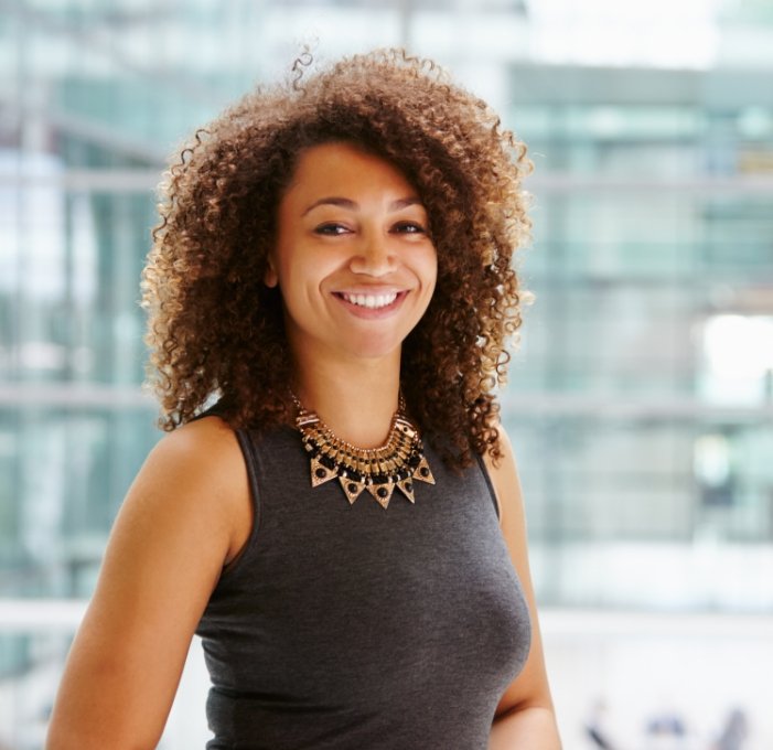 Woman in office smiling after root canal treatment in Mississauga