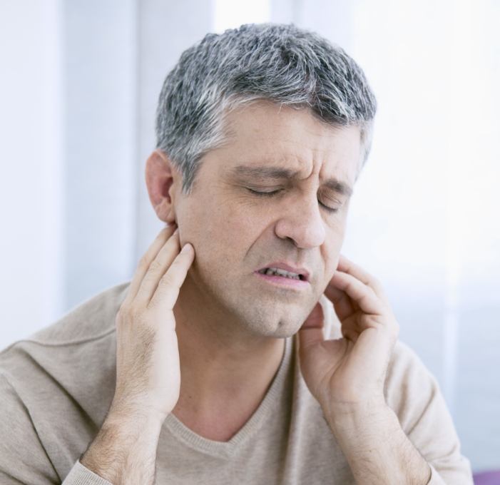 Man holding his jaw in pain before T M J treatment in Mississauga