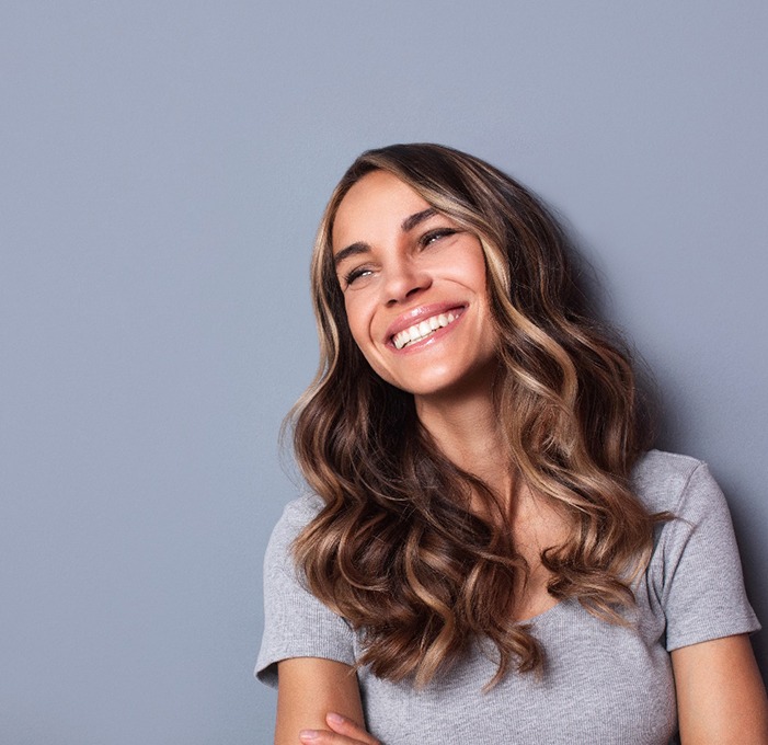 Smiling woman at a gray background