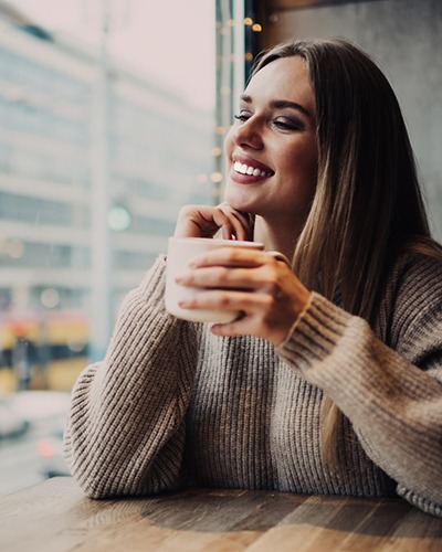 Woman with a white smile drinking coffee