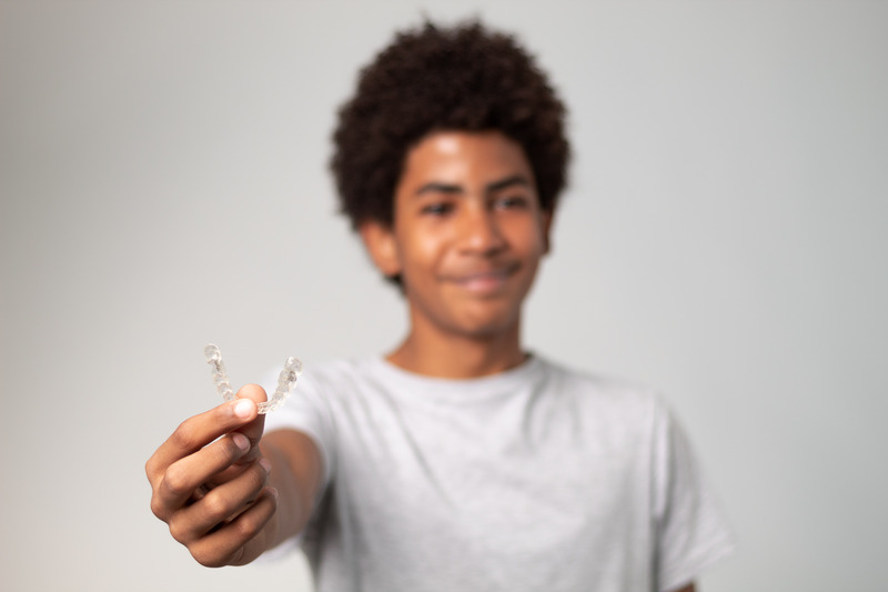 Patient holding their Invisalign aligner